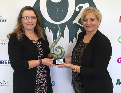 Colleen Zimmerman (left) holds the Chamber award with board member Christina Forth. 